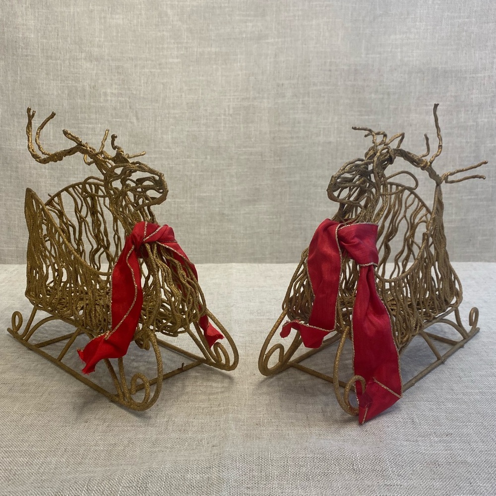 Two gold glittery wire reindeer sleigh Christmas decor with red ribbon.